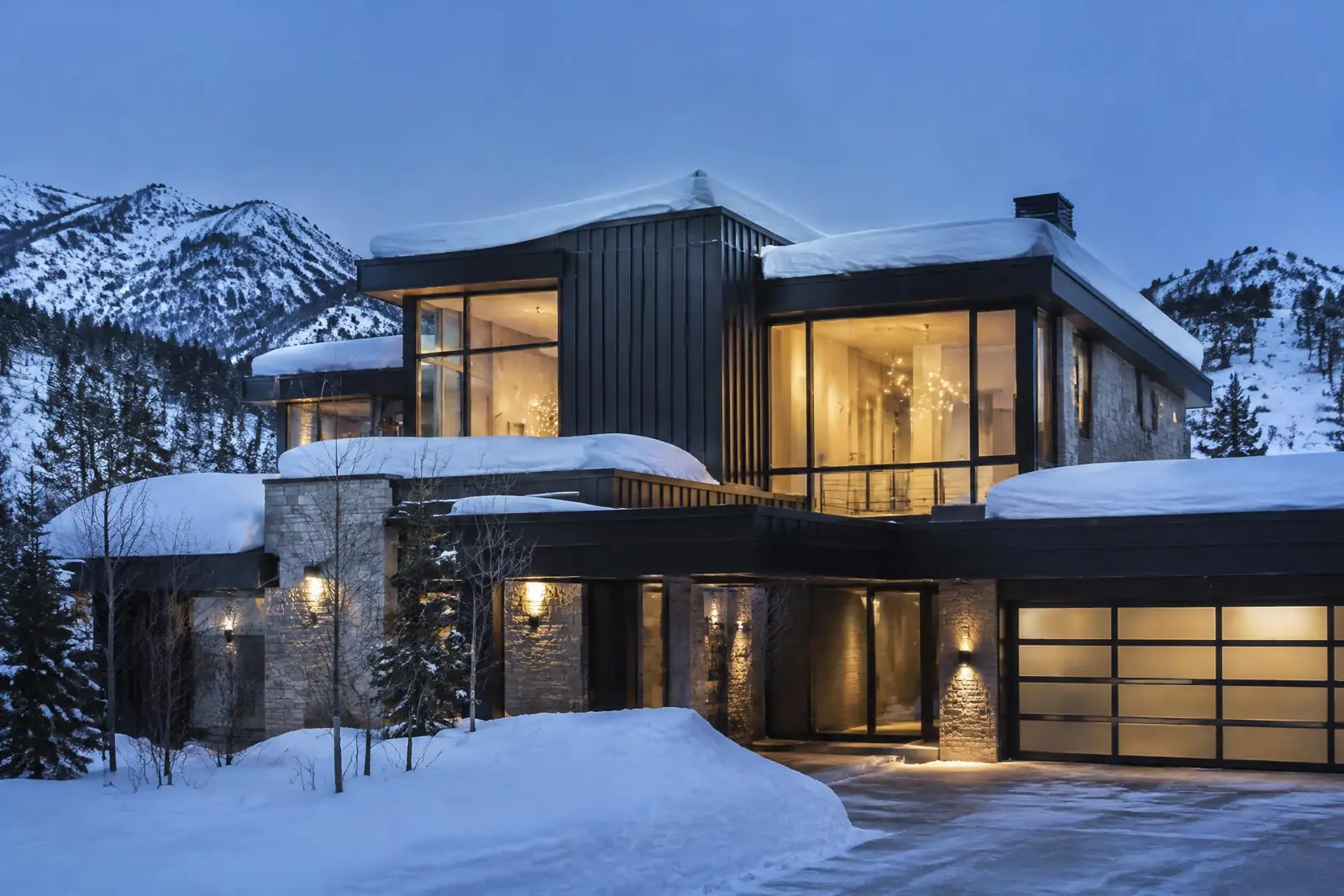 Luxury mountain-modern home under renovation in Park City, Utah with snow-covered Wasatch peaks in the background