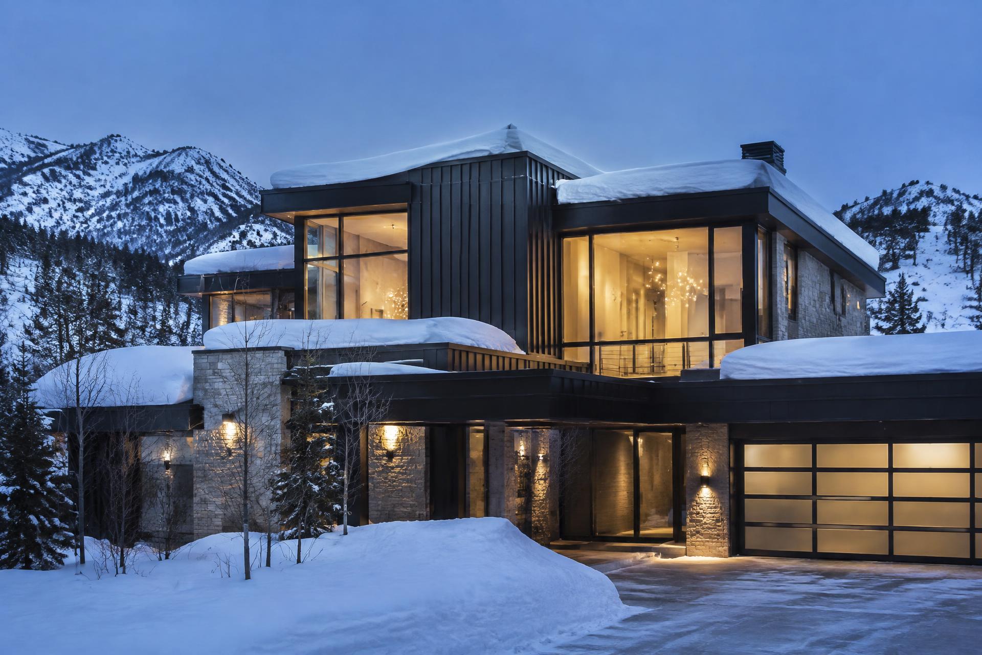 Luxury mountain-modern home under renovation in Park City, Utah with snow-covered Wasatch peaks in the background